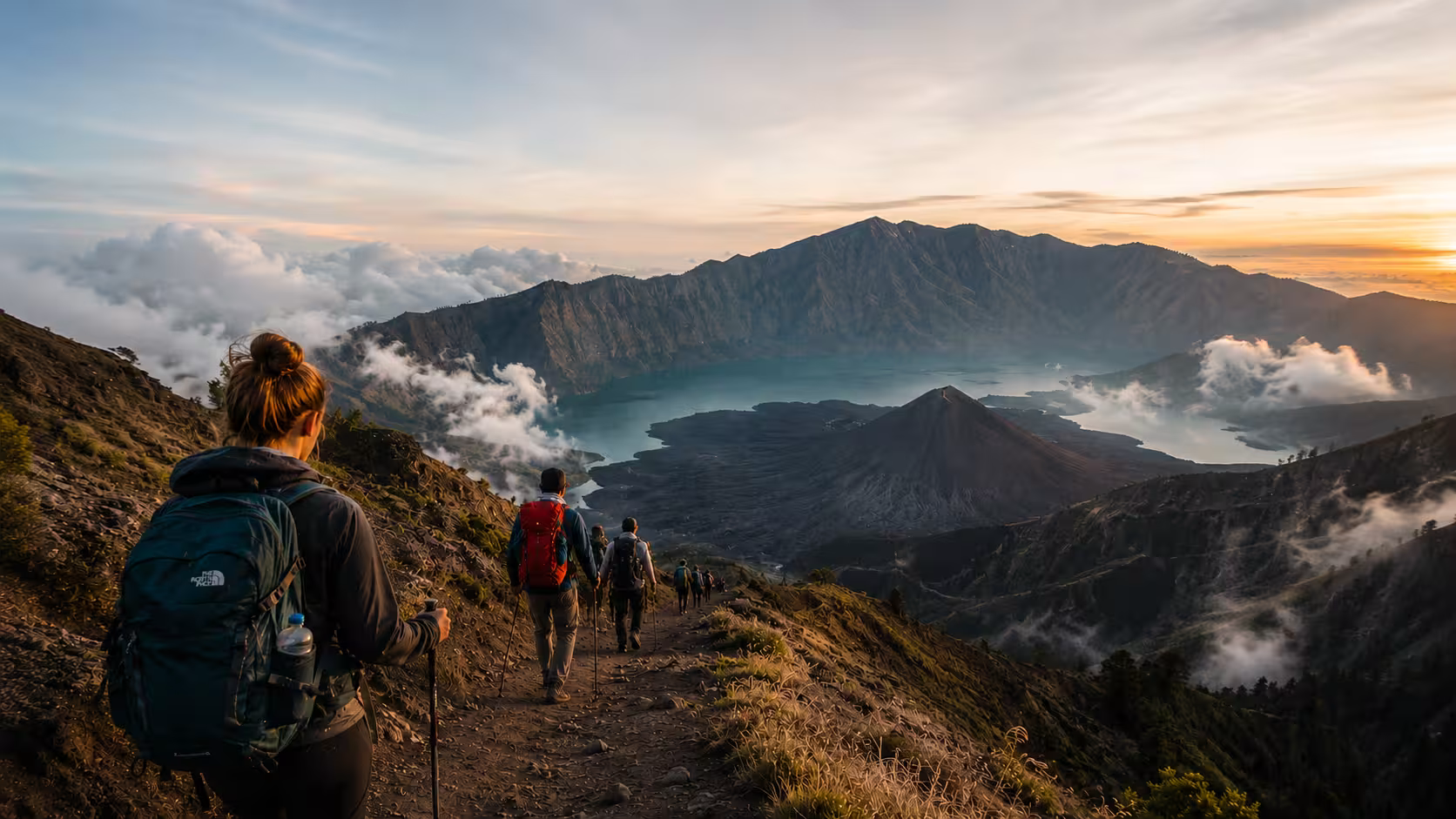 Hikers trekking along the stunning Mount Rinjani trail, enjoying panoramic views of the Segara Anak crater lake and the active volcanic cone.