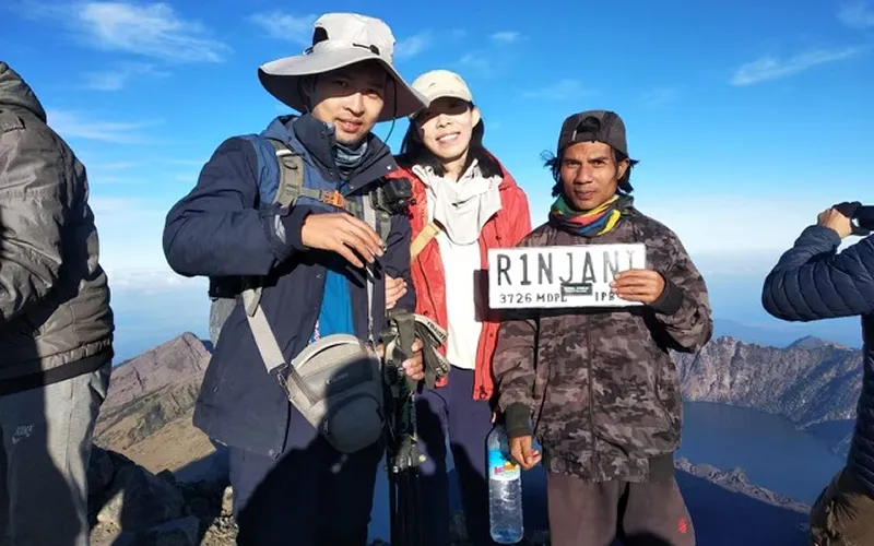 A group of hikers celebrating at the summit of Mount Rinjani after a 4-day trek via the Senaru route A group of hikers celebrating at the summit of Mount Rinjani after a 4-day trek via the Senaru route