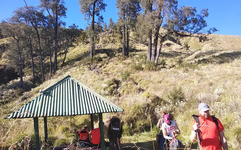 A group of hikers gathered around a small hut during their Mount Rinjani summit trek on the Sembalun route A group of hikers gathered around a small hut during their Mount Rinjani summit trek on the Sembalun route