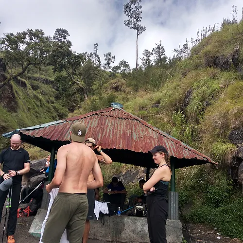 A group of hikers taking a break around a hut during their Mount Rinjani summit trek on the Sembalun route A group of hikers taking a break around a hut during their Mount Rinjani summit trek on the Sembalun route