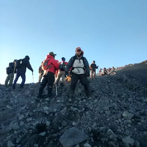 A group of hikers with backpacks on a mountain during the 3-day, 2-night Mount Rinjani trek back to Torean A group of hikers with backpacks on a mountain during the 3-day, 2-night Mount Rinjani trek back to Torean