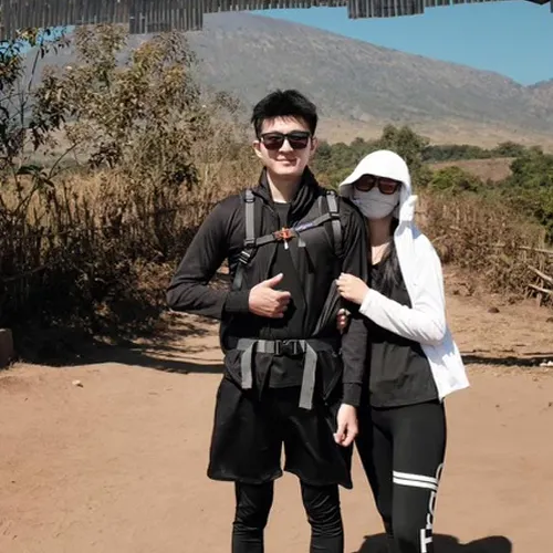 A man and woman in face masks stand on a dirt road, ready for their Mount Rinjani hike via the Sembalun route A man and woman in face masks stand on a dirt road, ready for their Mount Rinjani hike via the Sembalun route
