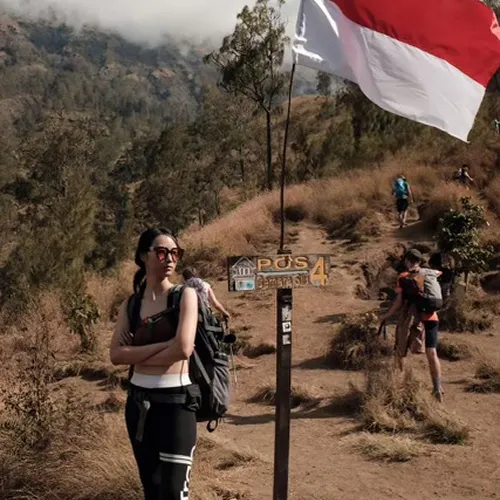 A woman poses next to an Indonesia sign, excited for her 4-day Mount Rinjani hike via Sembalun A woman poses next to an Indonesia sign, excited for her 4-day Mount Rinjani hike via Sembalun