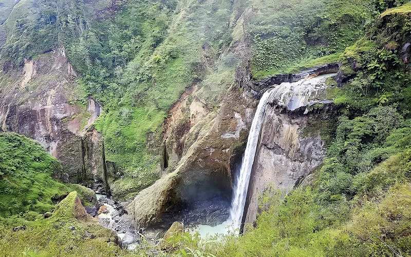 Enjoying a beautiful waterfall flows in a lush green valley, showcasing nature's tranquility and vibrant scenery during mount rinjani hike via torean Enjoying a beautiful waterfall flows in a lush green valley, showcasing nature's tranquility and vibrant scenery during mount rinjani hike via torean