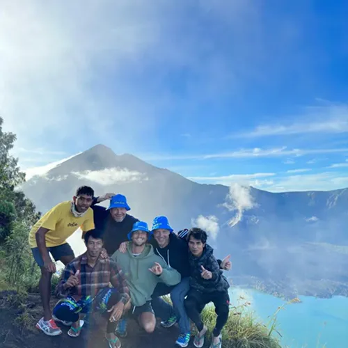 Friends posing together on top of Mount Rinjani, celebrating their successful hike at the Crater Rim Senaru Friends posing together on top of Mount Rinjani, celebrating their successful hike at the Crater Rim Senaru