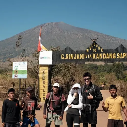 On a dirt road, a man and woman in face masks prepare for their hike up Mount Rinjani via the Sembalun route On a dirt road, a man and woman in face masks prepare for their hike up Mount Rinjani via the Sembalun route