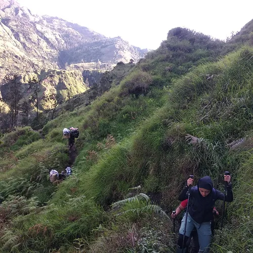 People hiking up a steep hill on Mount Rinjani, part of a three-day adventure from Torean to the summit People hiking up a steep hill on Mount Rinjani, part of a three-day adventure from Torean to the summit