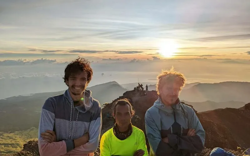 Three hikers smile for a photo at the summit of Mount Rinjani after a 4-day trek via the Senaru route Three hikers smile for a photo at the summit of Mount Rinjani after a 4-day trek via the Senaru route