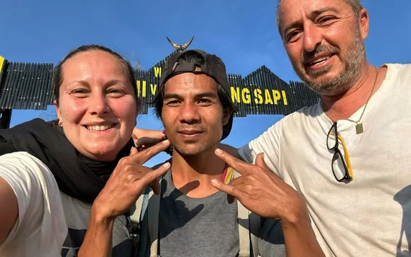 Three hikers smiling in front of a Mount Rinjani sign after their 4-day trek via the Senaru route Three hikers smiling in front of a Mount Rinjani sign after their 4-day trek via the Senaru route