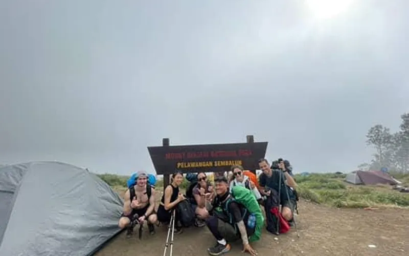 A group of hikers poses in front of a tent at the Pelawangan Sembalun campsite during their Mount Rinjani trek A group of hikers poses in front of a tent at the Pelawangan Sembalun campsite during their Mount Rinjani trek