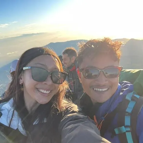 A man and woman smile for a selfie on Mount Rinjani, celebrating the sunrise during their 3-day trek via the Sembalun route A man and woman smile for a selfie on Mount Rinjani, celebrating the sunrise during their 3-day trek via the Sembalun route