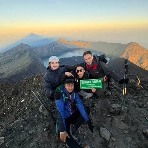 Four hikers pose triumphantly at the summit of Mount Rinjani, showcasing their achievement after a 3D2N trek via the Sembalun route Four hikers pose triumphantly at the summit of Mount Rinjani, showcasing their achievement after a 3D2N trek via the Sembalun route