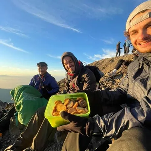 Three men enjoying a meal atop Mount Rinjani during a sunrise trek on the Sembalun route Three men enjoying a meal atop Mount Rinjani during a sunrise trek on the Sembalun route